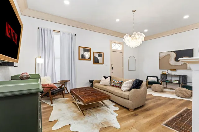 a living room with furniture a chandelier and a flat screen tv