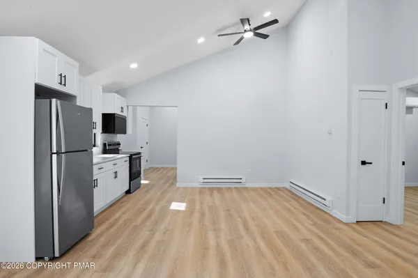 a view of a kitchen with a refrigerator and a sink
