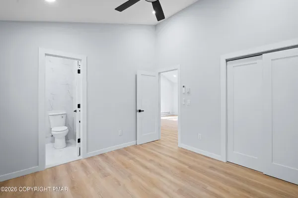 a view of a room with wooden floor and white doors