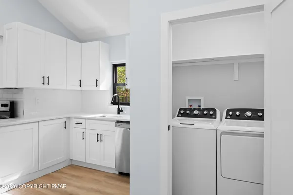a kitchen with white cabinets and white appliances