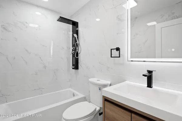 a bathroom with a sink a toilet and shower