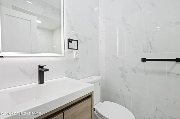 a bathroom with a sink a toilet and mirror