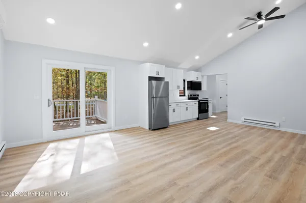 a view of a kitchen with a sink oven window and wooden floor
