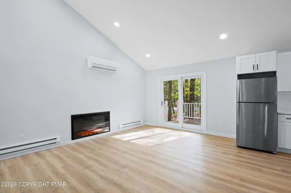 a view of empty room with wooden floor and fireplace