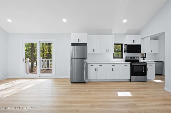 a kitchen with stainless steel appliances a refrigerator stove and microwave
