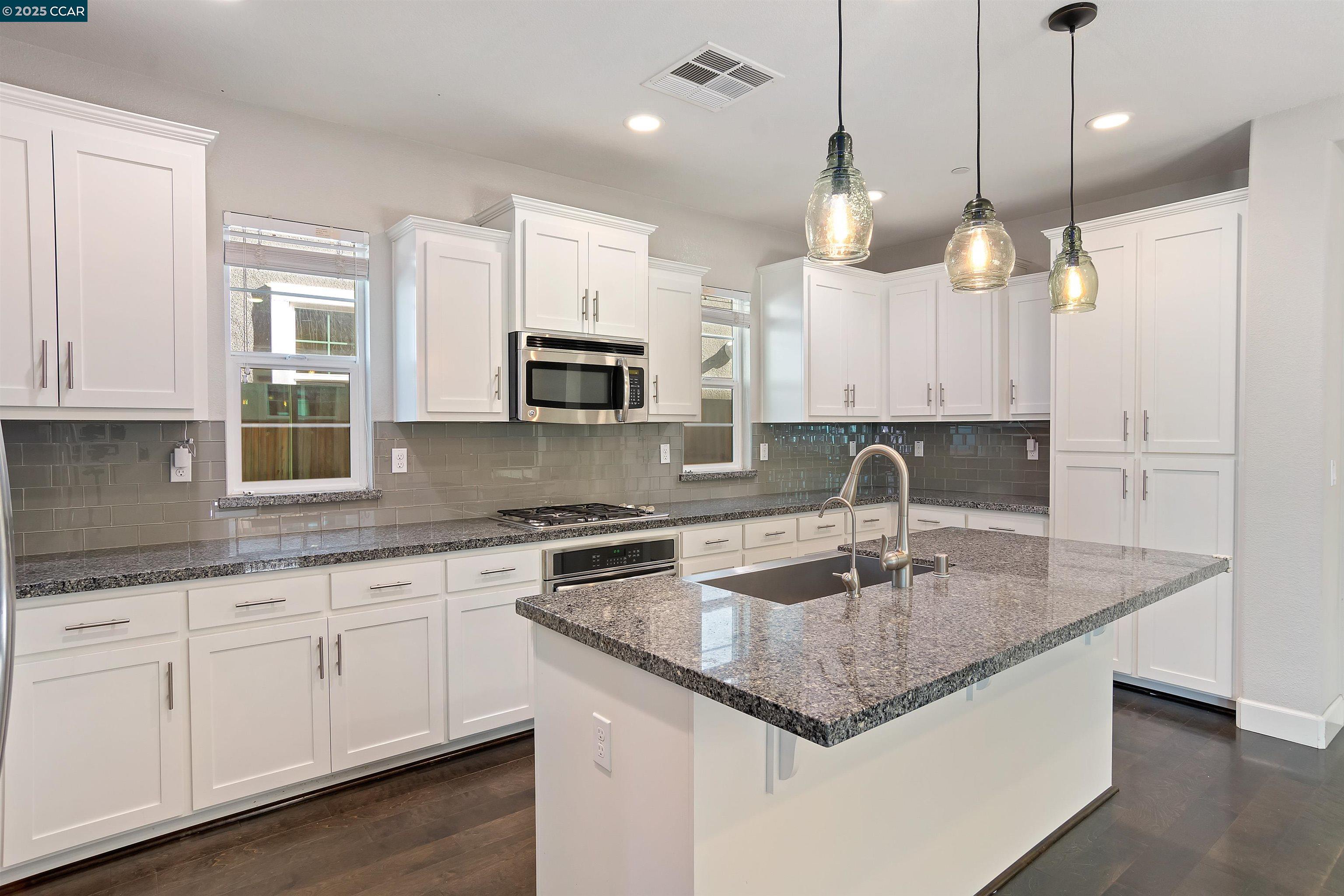 4969 Ivy Leaf Springs Road San Ramon, CA 94582 - Photo 13 of 34 a kitchen with kitchen island granite countertop a sink a counter space appliances and cabinets