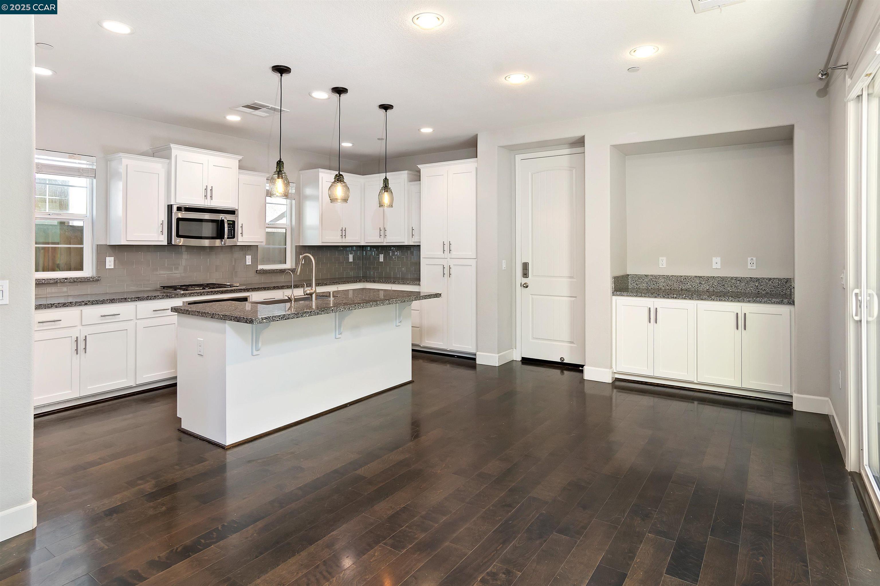 4969 Ivy Leaf Springs Road San Ramon, CA 94582 - Photo 10 of 34 a large kitchen with stainless steel appliances kitchen island a large counter top and a wooden floors