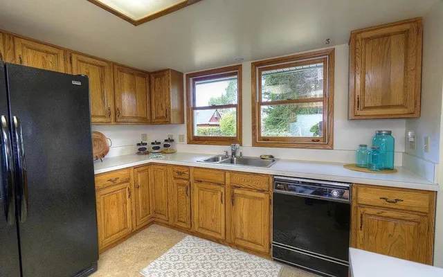 a kitchen with granite countertop stainless steel appliances a sink stove and refrigerator