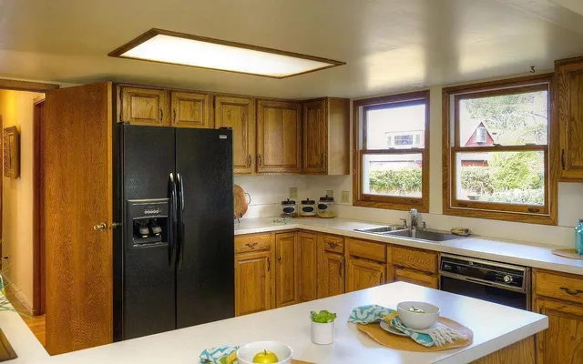 a kitchen with a sink a refrigerator and window