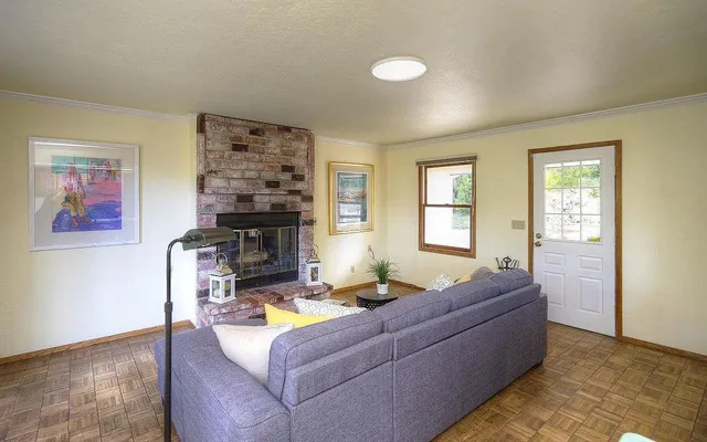 a living room with furniture a fireplace and a window