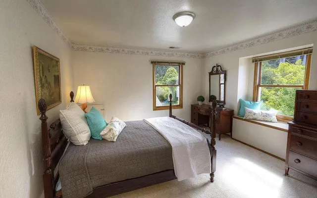 a bedroom with a large bed and windows