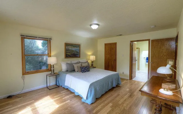 a bedroom with a bed and wooden floor
