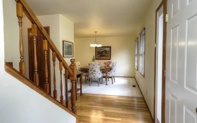 a view of a hallway with wooden floor and staircase