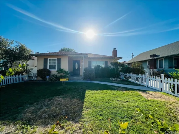 a view of a house with garden area and a yard