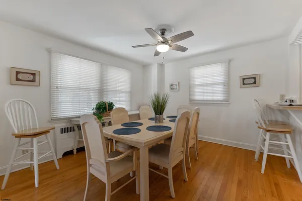 a dining room with furniture potted plants and wooden floor