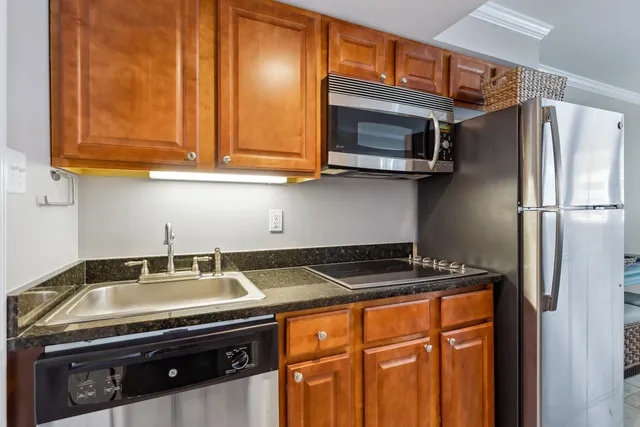a view of a kitchen with a sink and refrigerator