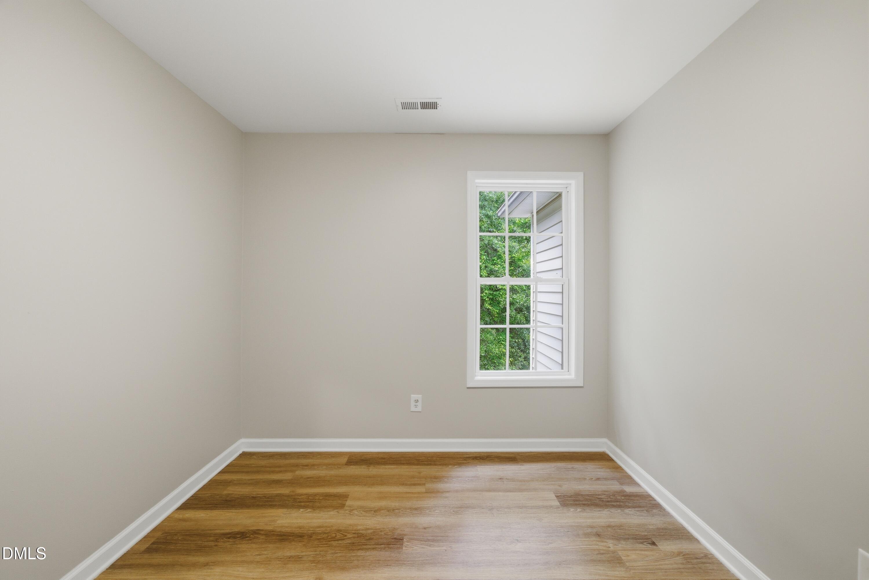 201 Tonylee Court, Unit A Raleigh, NC 27603 - Photo 30 of 30 a view of an empty room with wooden floor and a window
