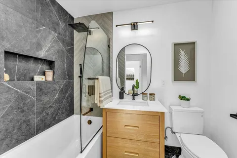 a en suite bathroom with a granite countertop sink and a mirror