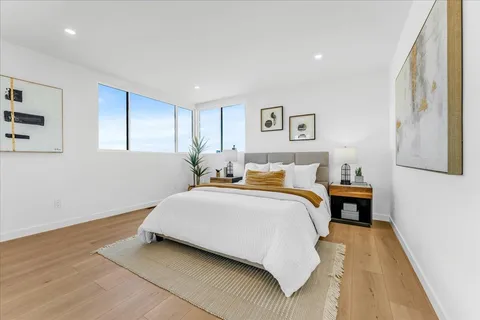 a spacious bedroom with a bed and a painting on the wall