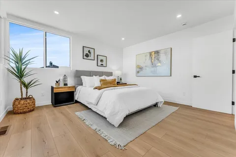 a bedroom with a large bed and a potted plant