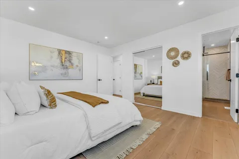 a bedroom with a bed and a painting on the wall