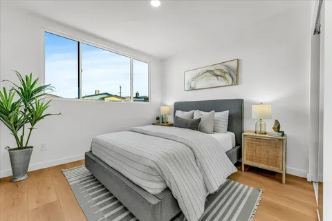 a bedroom with a large bed and a potted plant