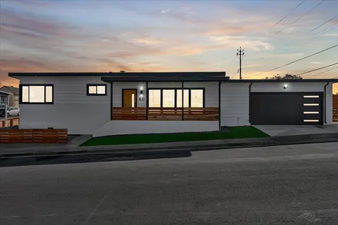 a front view of a house with a garden