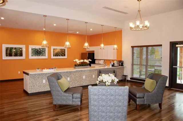 a living room with couches a dining table and kitchen view with wooden floor