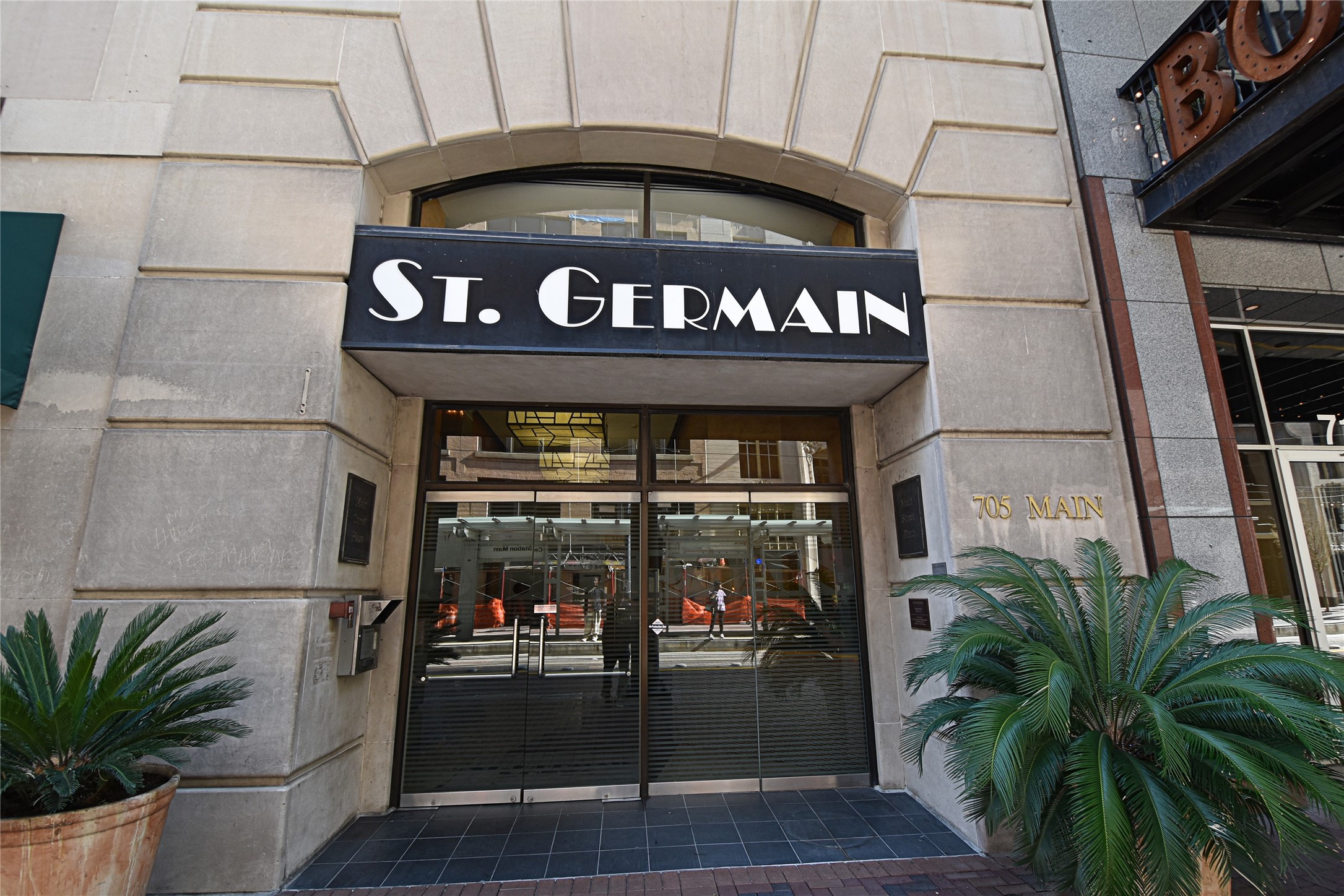 705 Main Street, Unit 215 Houston, TX 77002 - Photo 31 of 36 Tthe entrance to the St. Germain building, featuring a modern facade with large glass doors and a prominent sign.
