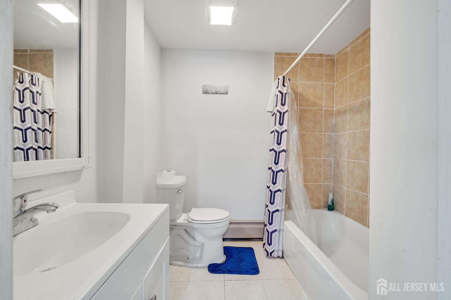 64 Commerce Street Perth Amboy, NJ 08861 - Photo 11 of 25 a bathroom with a sink a toilet and a bathtub