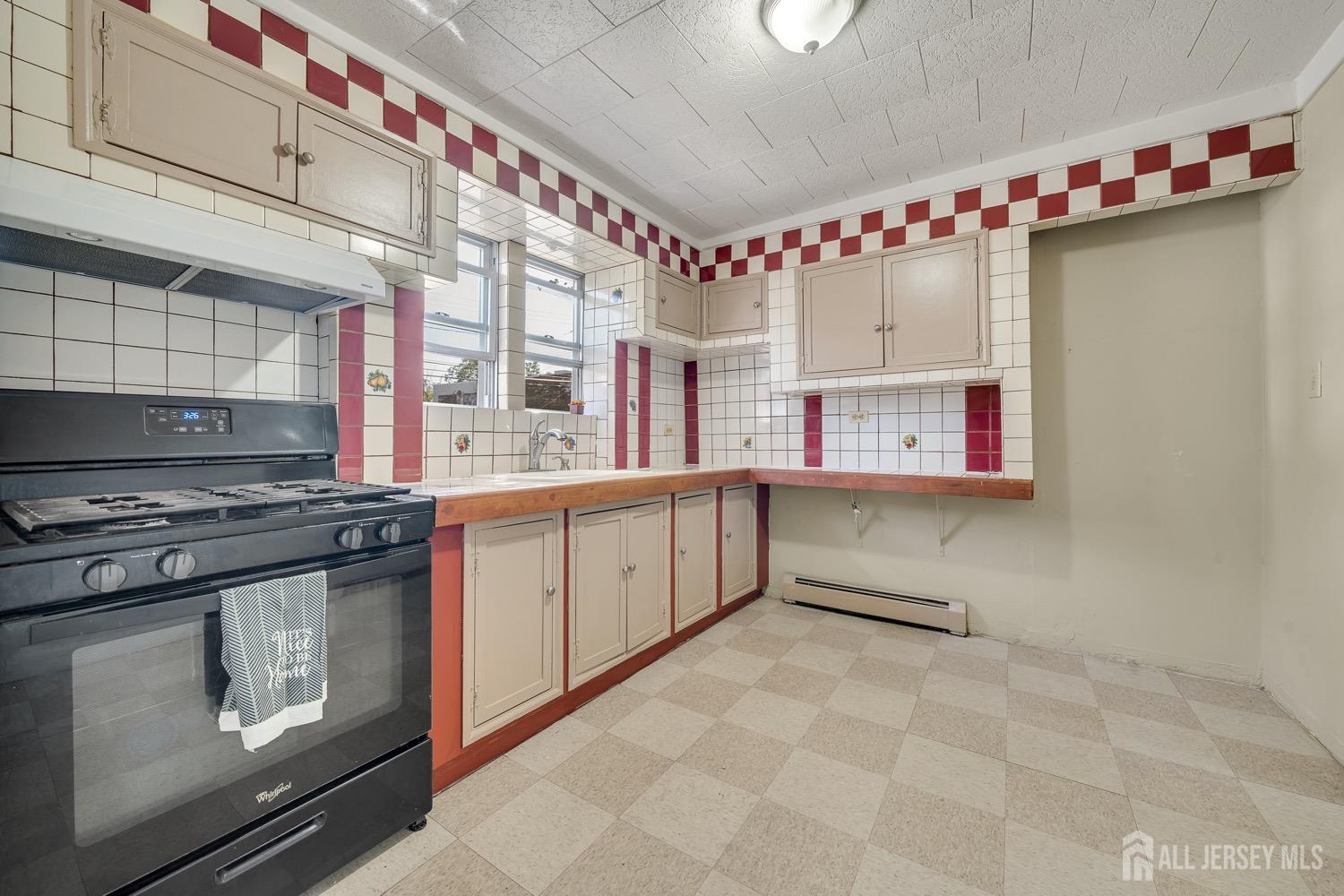 64 Commerce Street Perth Amboy, NJ 08861 - Photo 21 of 25 a kitchen with stainless steel appliances granite countertop a stove a sink dishwasher and cabinets