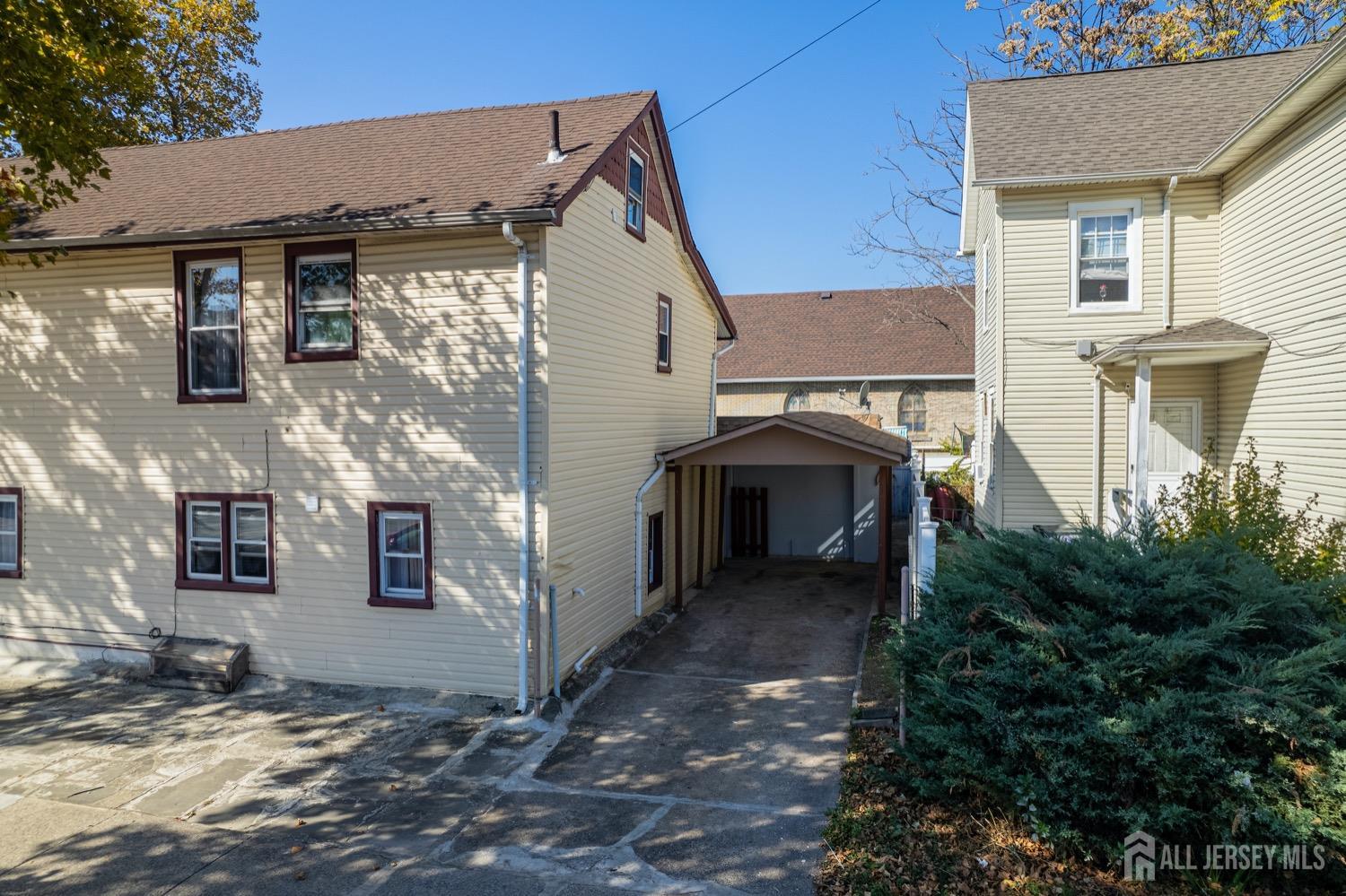 64 Commerce Street Perth Amboy, NJ 08861 - Photo 3 of 25 a view of a white house with many windows and a yard