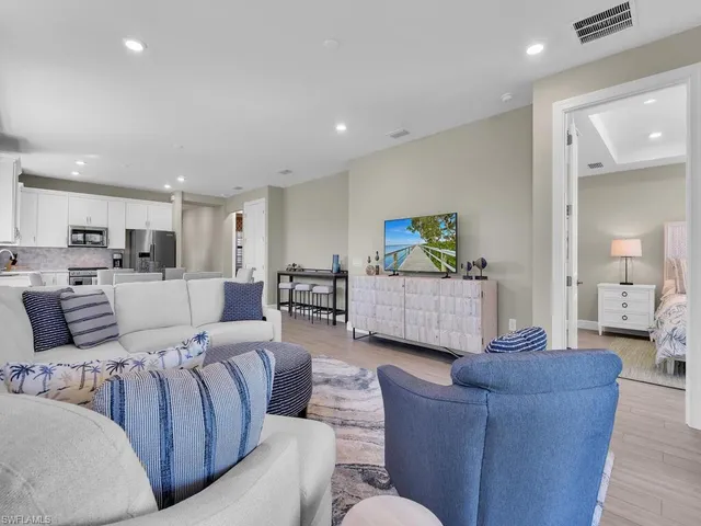 a living room with furniture and a view of kitchen