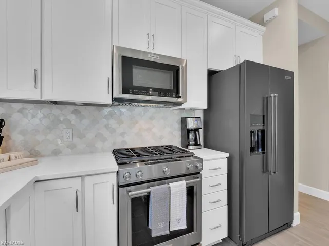 a kitchen with stainless steel appliances a stove microwave and refrigerator