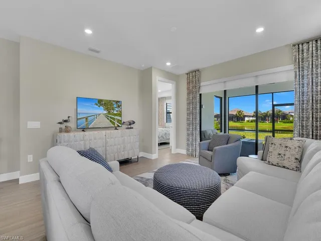 a living room with furniture large window and a flat screen tv