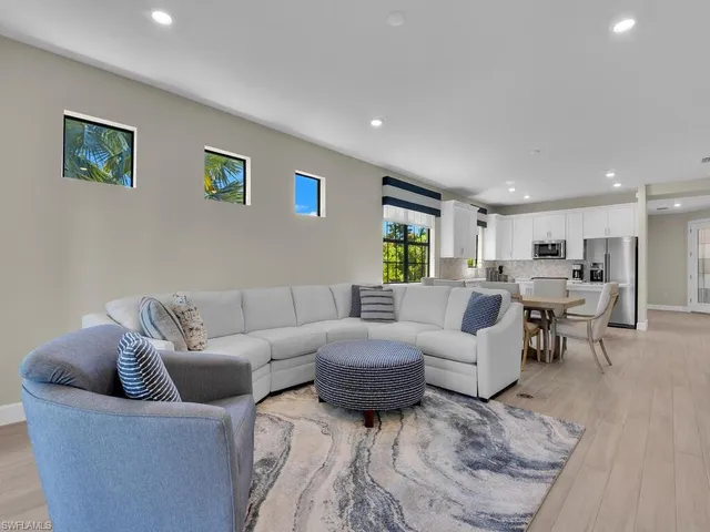 a living room with furniture wooden floor and a view of kitchen