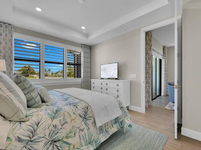 a bedroom with a bed and a large window