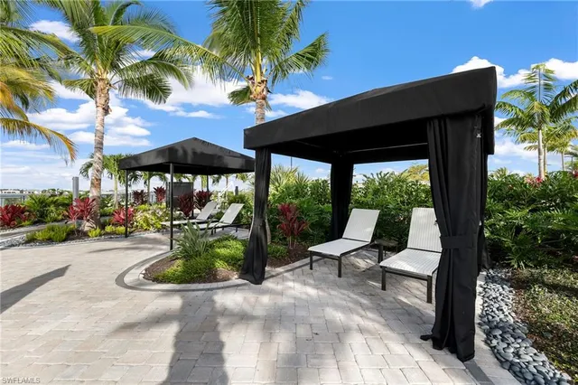 a view of a patio with table and chairs under an umbrella with a patio