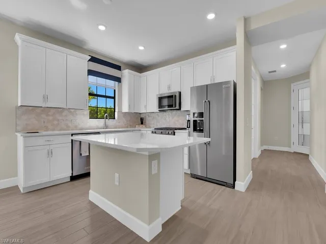 a kitchen with a refrigerator stove top oven and sink