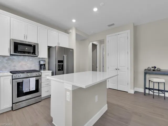 a kitchen with stainless steel appliances a stove microwave and refrigerator