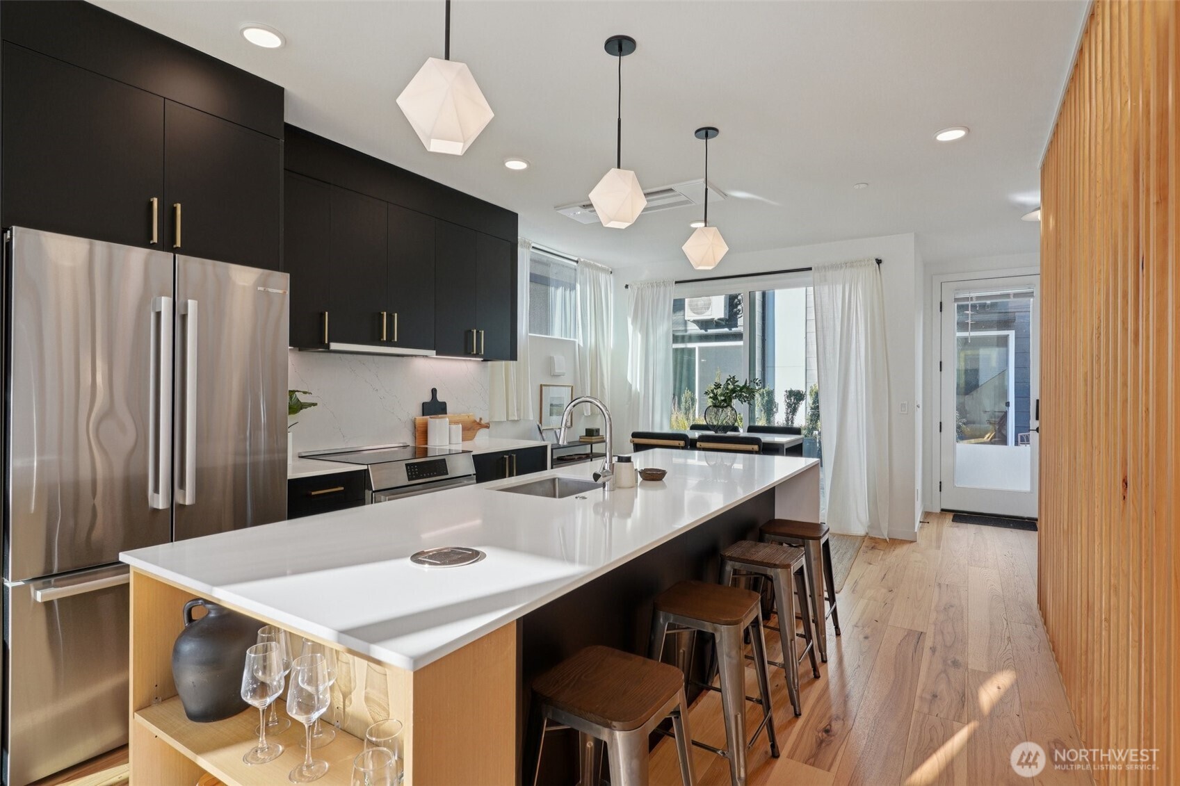 515 Howe Street, Unit A Seattle, WA 98109 - Photo 4 of 40 a kitchen with kitchen island a stove a sink a refrigerator and chairs