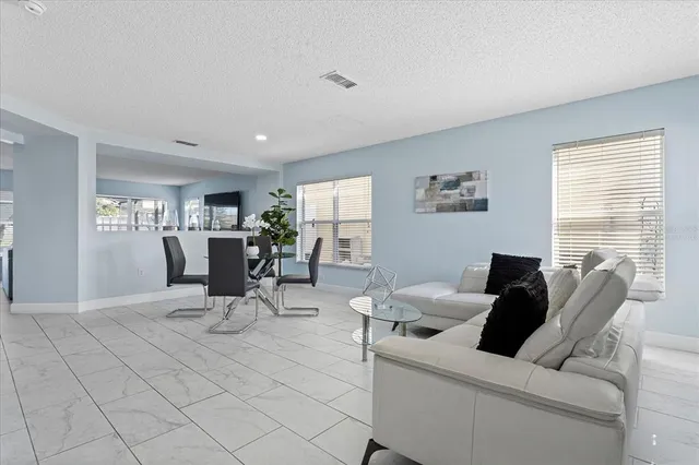 a living room with furniture a table and a large window