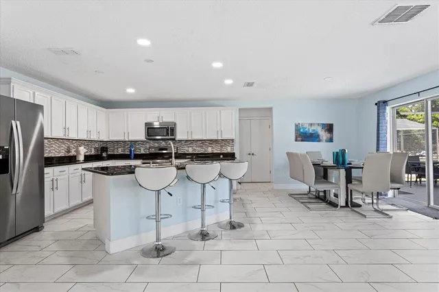a kitchen with stainless steel appliances kitchen island granite countertop a sink and cabinets