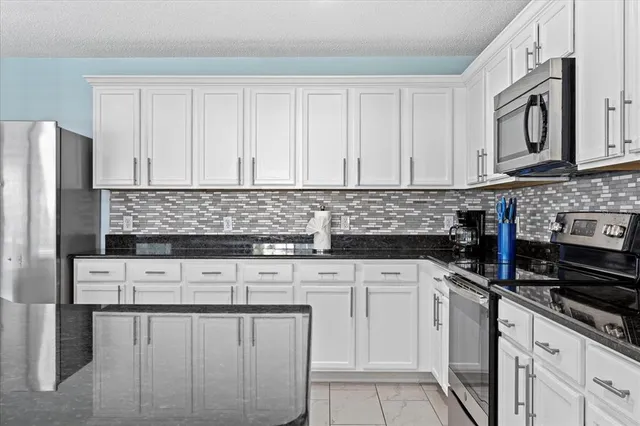 a kitchen with stainless steel appliances granite countertop a sink stove and cabinets