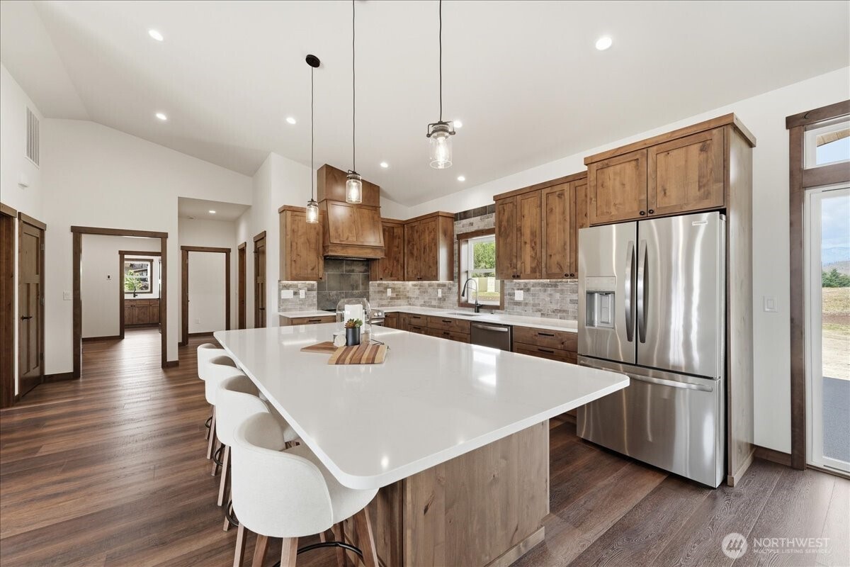 110 Slide View Lane Manson, WA 98831 - Photo 12 of 38 a kitchen with stainless steel appliances a dining table chairs refrigerator and wooden floor
