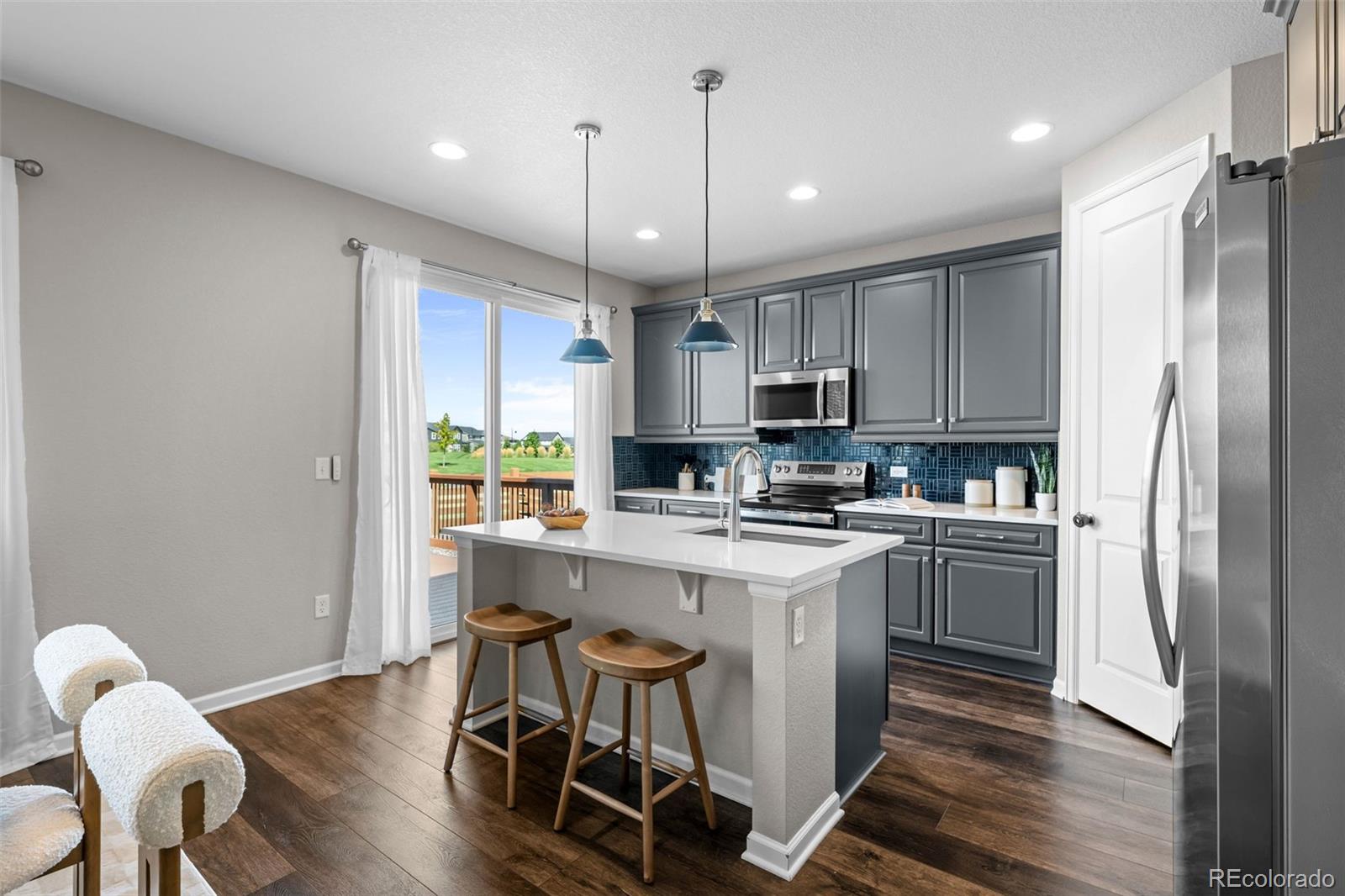 450 Pikes View Drive Erie, CO 80516 - Photo 12 of 45 a kitchen with kitchen island stainless steel appliances a stove a sink a refrigerator cabinets and chairs