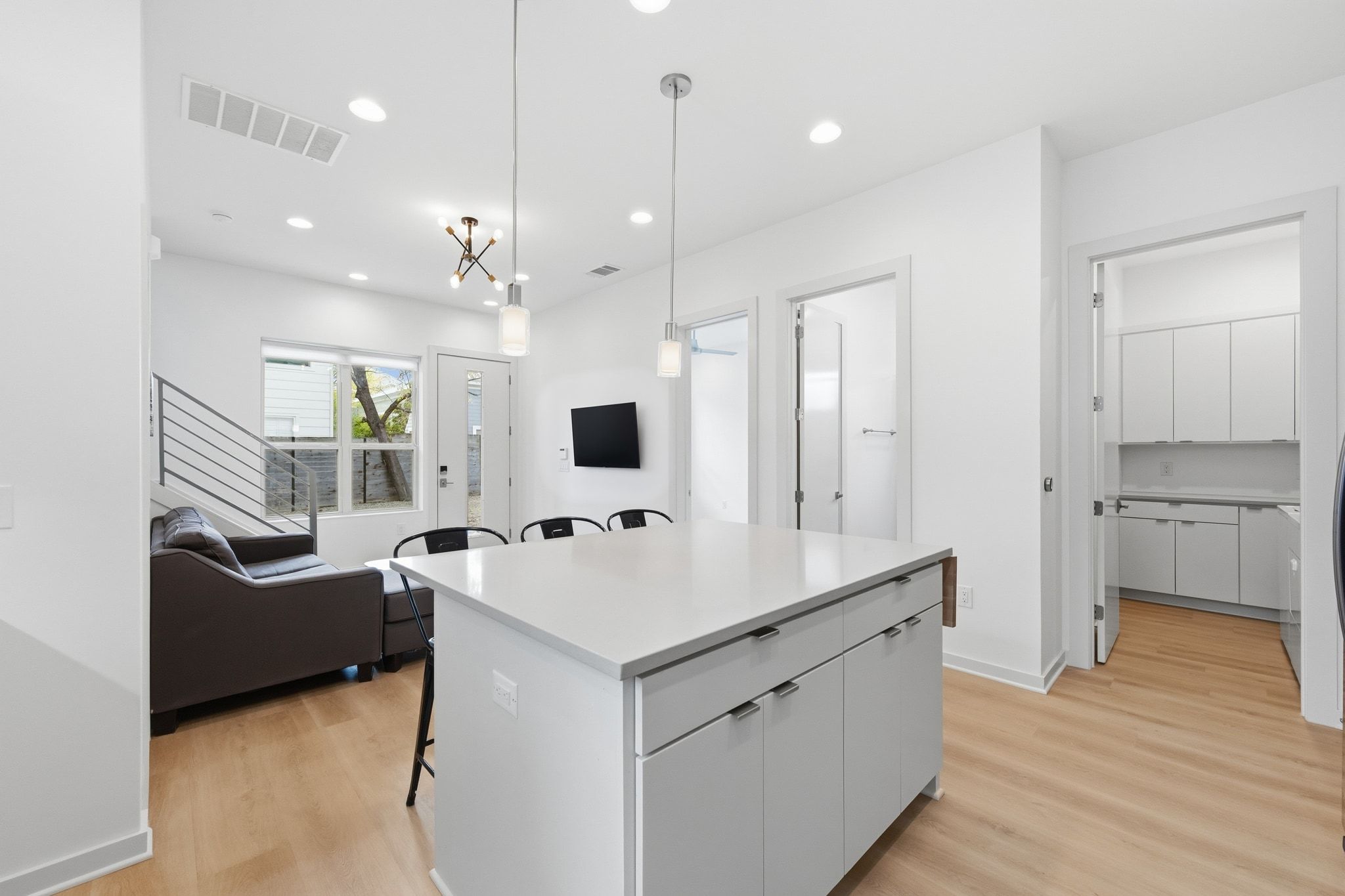 2811 Garwood Street, Unit B Austin, TX 78702 - Photo 11 of 24 Kitchen with a breakfast bar area, pendant lighting, a kitchen island, light wood-type flooring, and white cabinets