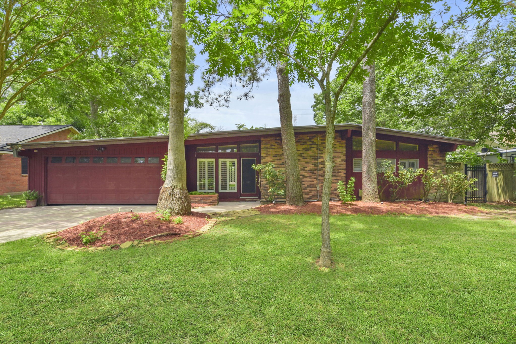 a front view of a house with a yard and trees