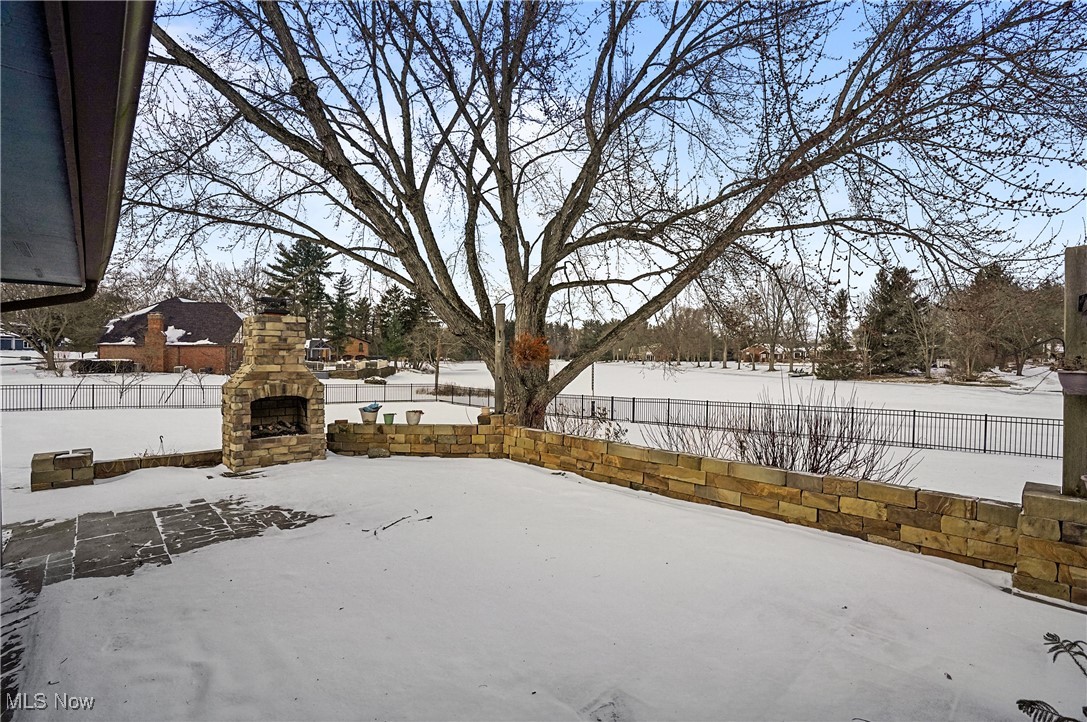 1094 San Raphael Drive Akron, OH 44333 - Photo 44 of 50 Yard covered in snow featuring a fenced backyard, an outdoor stone fireplace, and a patio