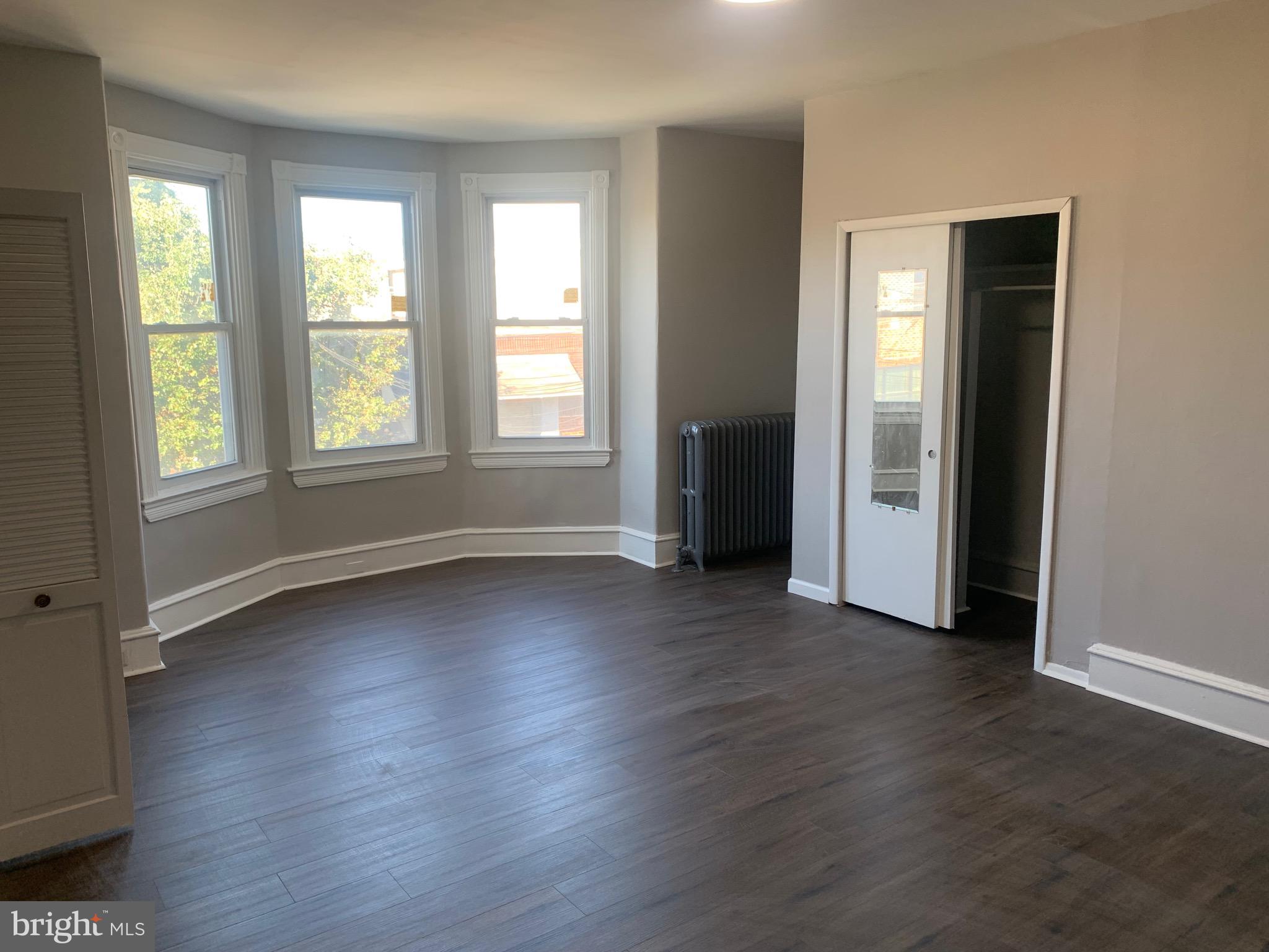 2387 Orthodox Street Philadelphia, PA 19137 - Photo 4 of 12 an empty room with wooden floor and windows